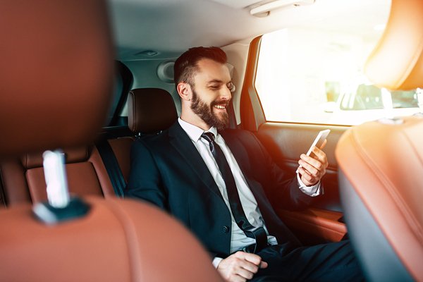 Handsome Businessman With Phone On Hand Sitting On The Backseat